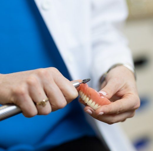 Dental lab technician crafting denture